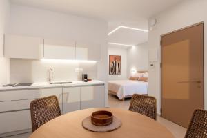 a kitchen and dining room with a table and a bed at IONE Suites in Preveza