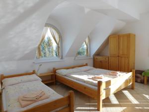 een slaapkamer met 2 bedden en 2 ramen bij Penzion Petko in Dolný Smokovec