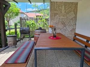 a wooden table with a bottle of wine on a patio at Chalupa Varechovsky potok in Vysoká nad Kysucou