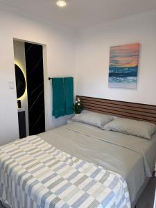 a bedroom with two beds and a painting on the wall at The Hideaway Cabin Barbados in Christ Church