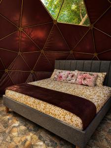 a bed in a room with a red wall at Vega Glamping in La Vega