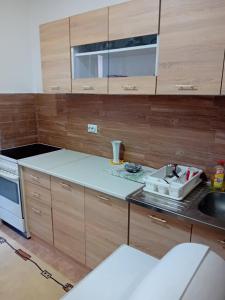 a kitchen with wooden cabinets and a sink at Smestaj Prokuplje in Prokuplje