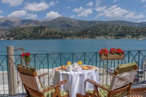 a table on a balcony with a view of the water at Argostοli Bay Apartments in Argostoli
