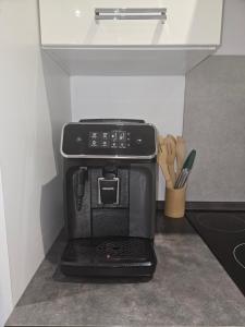 a black coffee maker sitting on top of a counter at Ma p'tite maison in Fumay +4 photos