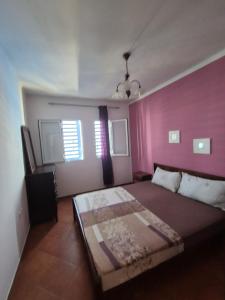 a bedroom with a large bed with pink walls at Jawhara smir 2ET vue piscine in M'diq