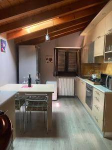 a kitchen with a table and chairs in a room at casa vacanze LA CA Del Cunfec in Sondrio