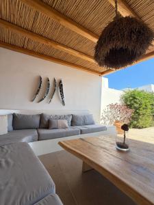 a living room with a couch and a wooden table at Villa Olympia with private pool in Antiparos