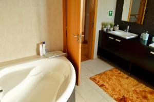 a bathroom with a bath tub and a sink at Cantinho do Minho - Ponte de Lima in Ponte de Lima