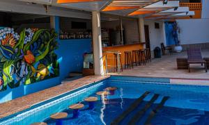 a swimming pool with stools next to a bar at Porto Cálem Praia Hotel in Porto Seguro