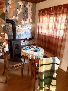 a dining room with a table and a wood stove at Rokova Dolina in Draganovac
