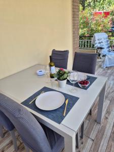 a table with a white plate and wine glasses at Casa Sabina in Sanremo