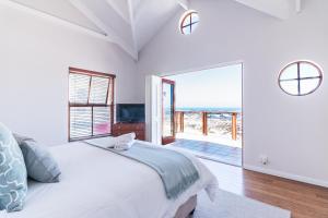 a bedroom with a bed and a view of the ocean at Geheim Luxury Seafront in Hermanus