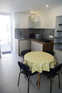 a kitchen with a table and chairs in a kitchen at Jolie T2, RDC, Proche du lac in Aix-les-Bains