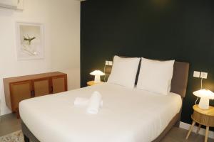 a bedroom with a large white bed with two lamps at Jolie T2, RDC, Proche du lac in Aix-les-Bains