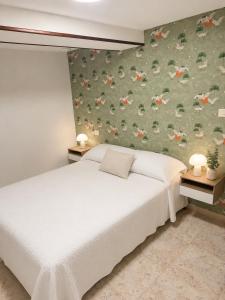 a bedroom with two beds and a floral wallpaper at Casa Estraviz in A Coruña +11 photos