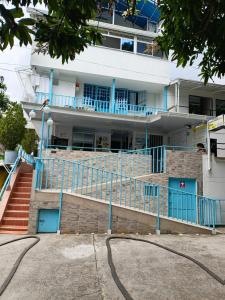 a building with blue railing and stairs in front of it at Posada El Carro Amarillo SAS in Floridablanca