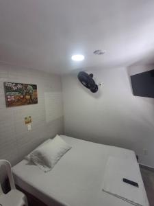 a small room with a bed and a phone on the wall at Posada El Carro Amarillo SAS in Floridablanca