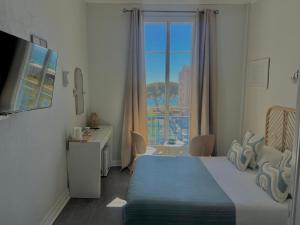 a hotel room with a bed and a window at Hôtel Eden - La Baigneuse in Juan-les-Pins