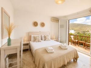 a bedroom with a bed and a table and a balcony at Villa Sofia in Agios Petros +52 photos