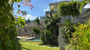 an image of a house with a swimming pool and plants at Villa Lombok Surga Kedua Setangi in Mangsit