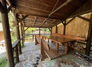 a wooden table and benches in a pavilion at Rokova Dolina in Draganovac +10 photos