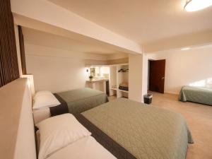 a hotel room with two beds and a bathroom at Hotel Miramar - La Paz in La Paz