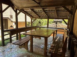 a patio with a table and benches in a pavilion at Rokova Dolina in Draganovac