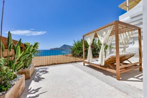 a swing on a patio with the ocean in the background at Las Torres by Santas Hotels in Altea