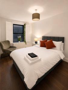 a bedroom with a bed with a book on it at Cosy Coach House - Belfast in Belfast