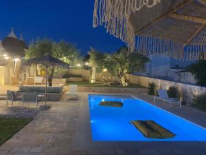 a pool in a backyard at night at Dimora Dormio in Monopoli