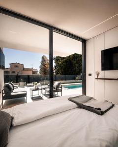 a bedroom with a large white bed and a large window at Villa9eleven in Novigrad Istria