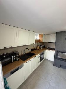a kitchen with white cabinets and a sink at Widokowy zakątek niedaleko Energylandi apartament Zator in Zator