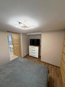a bedroom with a bed and a dresser and a television at Widokowy zakątek niedaleko Energylandi apartament Zator in Zator