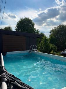 a swimming pool with blue water in front of a building at Widokowy zakątek niedaleko Energylandi apartament Zator in Zator
