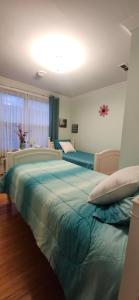 ein Schlafzimmer mit zwei Betten und einem großen grünen Bett in der Unterkunft Tripp Inn in St. John's