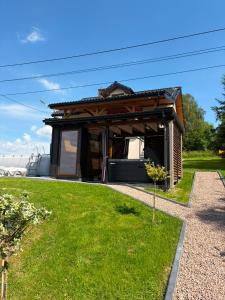 a small house with a roof on a grass field at Widokowy zakątek niedaleko Energylandi apartament Zator in Zator