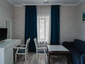 a living room with a couch and a table and chairs at WhiteHotelGabala in Gabala