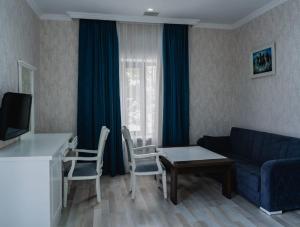 a living room with a blue couch and a table at WhiteHotelGabala in Gabala