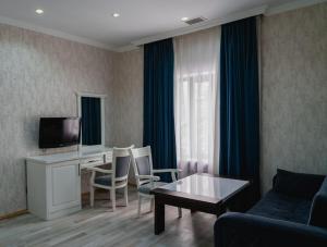 a living room with a couch and a table with chairs at WhiteHotelGabala in Gabala