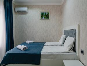 a bedroom with a bed with two towels on it at WhiteHotelGabala in Gabala +45 photos