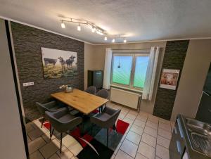 a dining room with a wooden table and chairs at Ferienwohnung Mutter in Twiste +4 photos