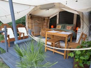 a tent with a table and chairs on a deck at Zapach Morza - A Casa Mia in Niechorze +15 photos