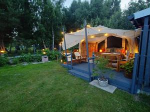 a tent with a table and chairs in a yard at Zapach Morza - A Casa Mia in Niechorze