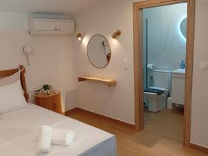 a bedroom with a bed and a mirror and a bathroom at Nerina House in Paralia Katerinis