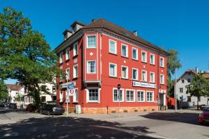 a red building on the corner of a street at Hotel Romäus in Villingen-Schwenningen
