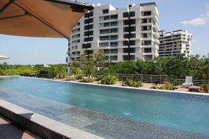 a swimming pool in front of a tall building at Panoramic Lake View Cabo Norte Mérida in Mérida