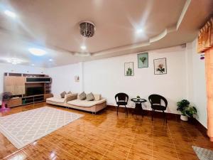 a living room with a couch and a table and chairs at The Warm House in Ban Komo Sip Paet