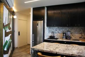 a kitchen with black cabinets and a granite counter top at Panoramic Lake View Cabo Norte Mérida in Mérida