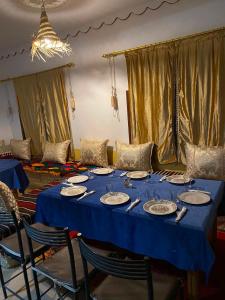 a blue table with plates and utensils on it at maison isabel in Boumalne Dades +53 photos