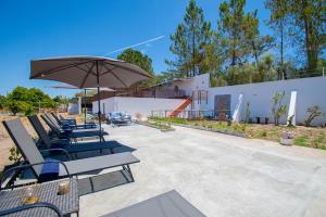a group of chairs and an umbrella on a patio at Ufitness Villa Algarve in Vila Real de Santo António
